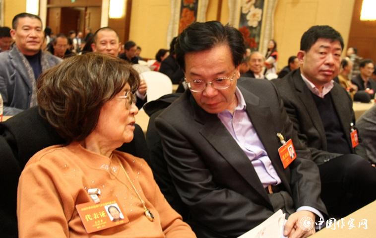 文潔若、李福明等代表在報告會前交談。