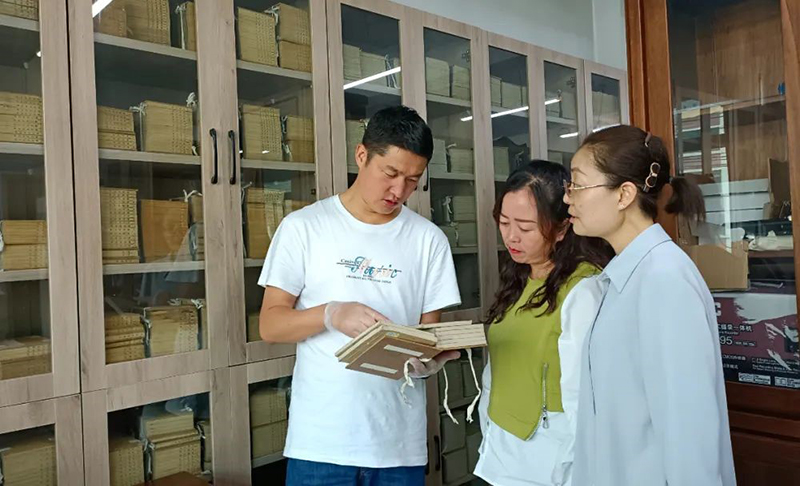 張旻（左）在大通縣圖書館了解、翻閱清代印制的經史子集典籍