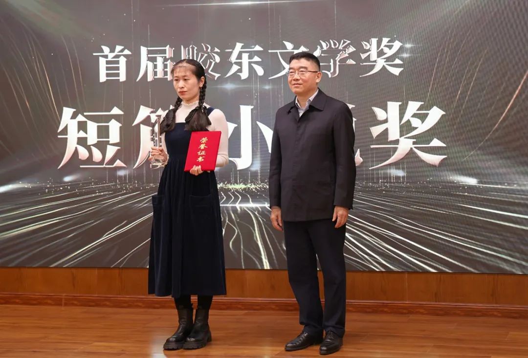 山東省作協(xié)黨組書(shū)記、副主席趙藝?。ㄓ乙唬? 為短篇小說(shuō)獎(jiǎng)獲得者王銘嬋頒獎(jiǎng)