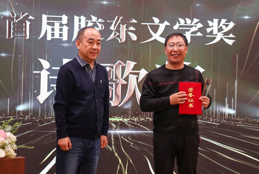 《詩(shī)選刊》主編  著名詩(shī)人、評(píng)論家桫欏（左一）  為詩(shī)歌獎(jiǎng)獲得者江一葦頒獎(jiǎng)