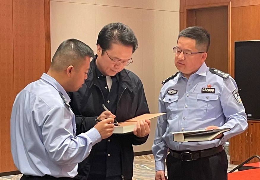 活動期間，陳彥（圖中）在給警營作家簽名。